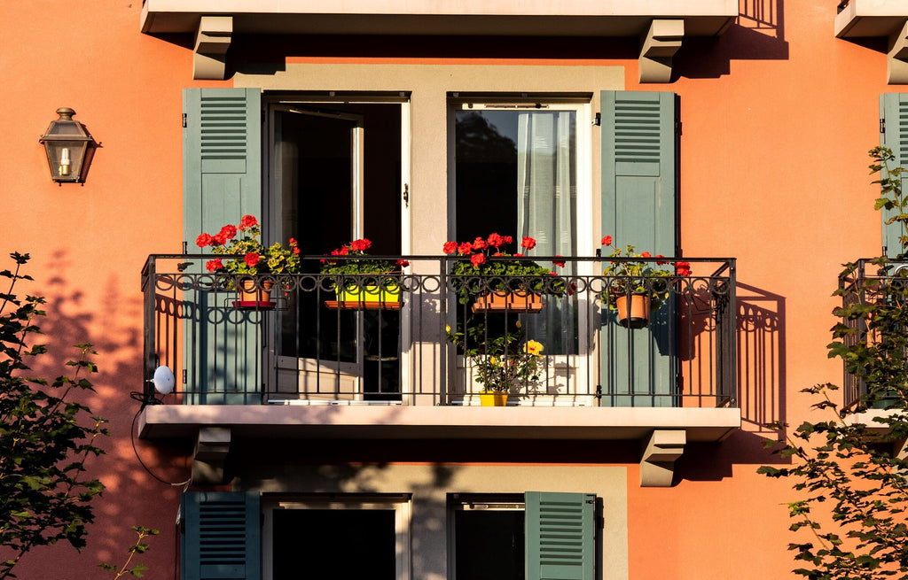 Balkon mit Blumen an einem orangen Hauses