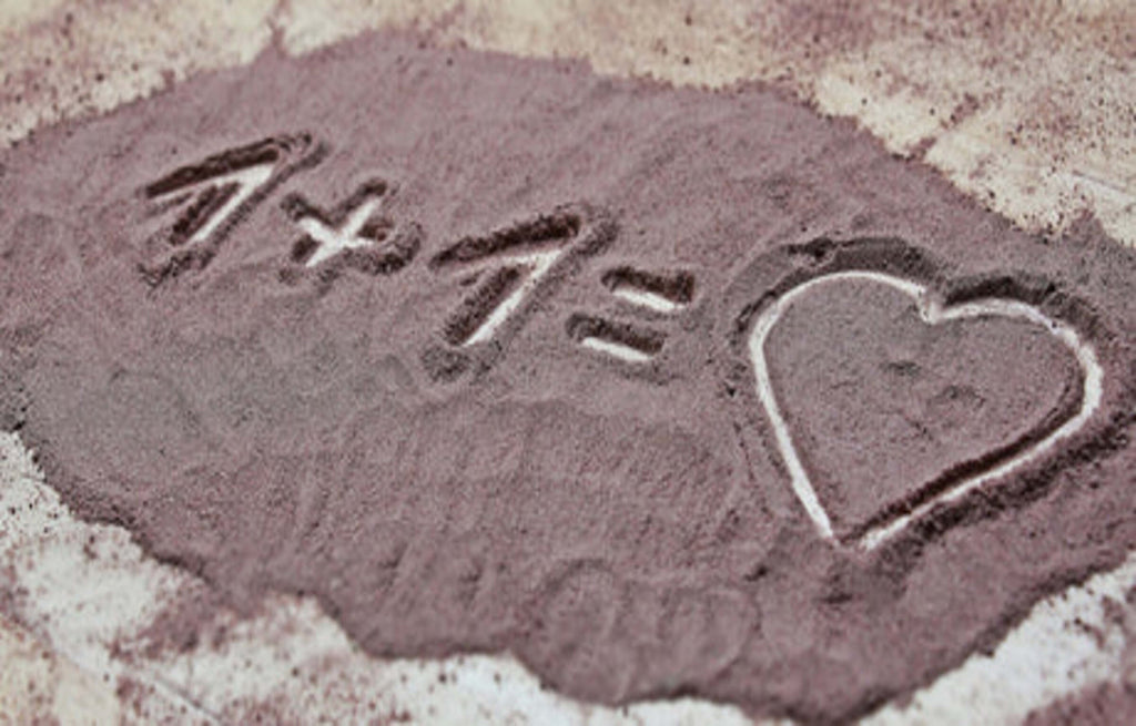 Im Sand steht 1+1 gleich Herz geschrieben